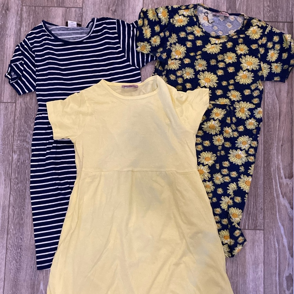 Three dresses - yellow, blue and white striped, navy and yellow flowers.